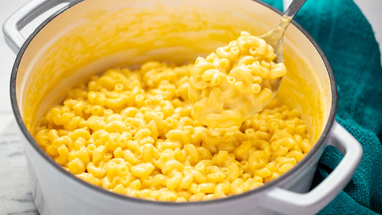 Mac e formaggio in una pentola bianca con un cucchiaio