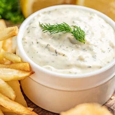 Homemade tartar sauce in a white serving bowl with chips on the side