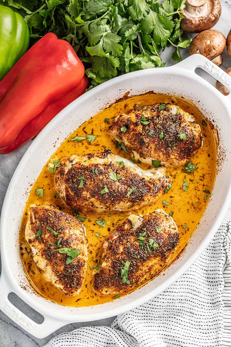 Cajun stuffed chicken breasts in a white baking dish