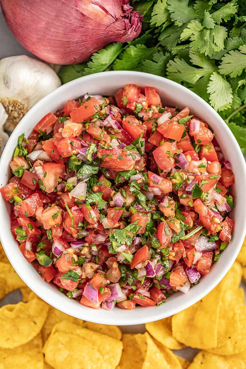 Overhead view of a white bowl filled with homemade salsa