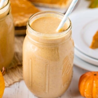 pumpkin pie oatmeal smoothie in a glass jar with a straw sticking out