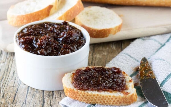 A bowl of bacon jam and a slice of bread covered in bacon jam.