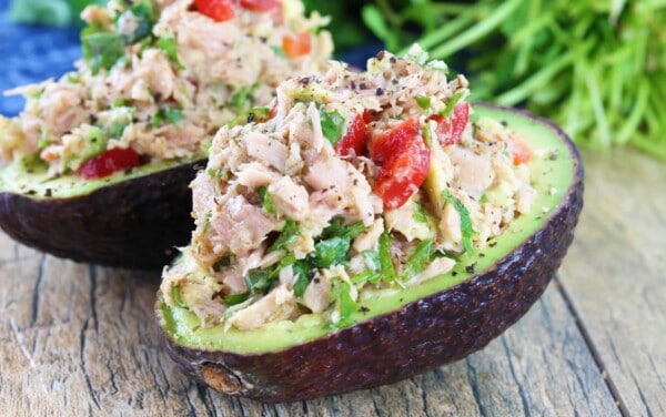 Two tuna stuffed avocados on a table top.