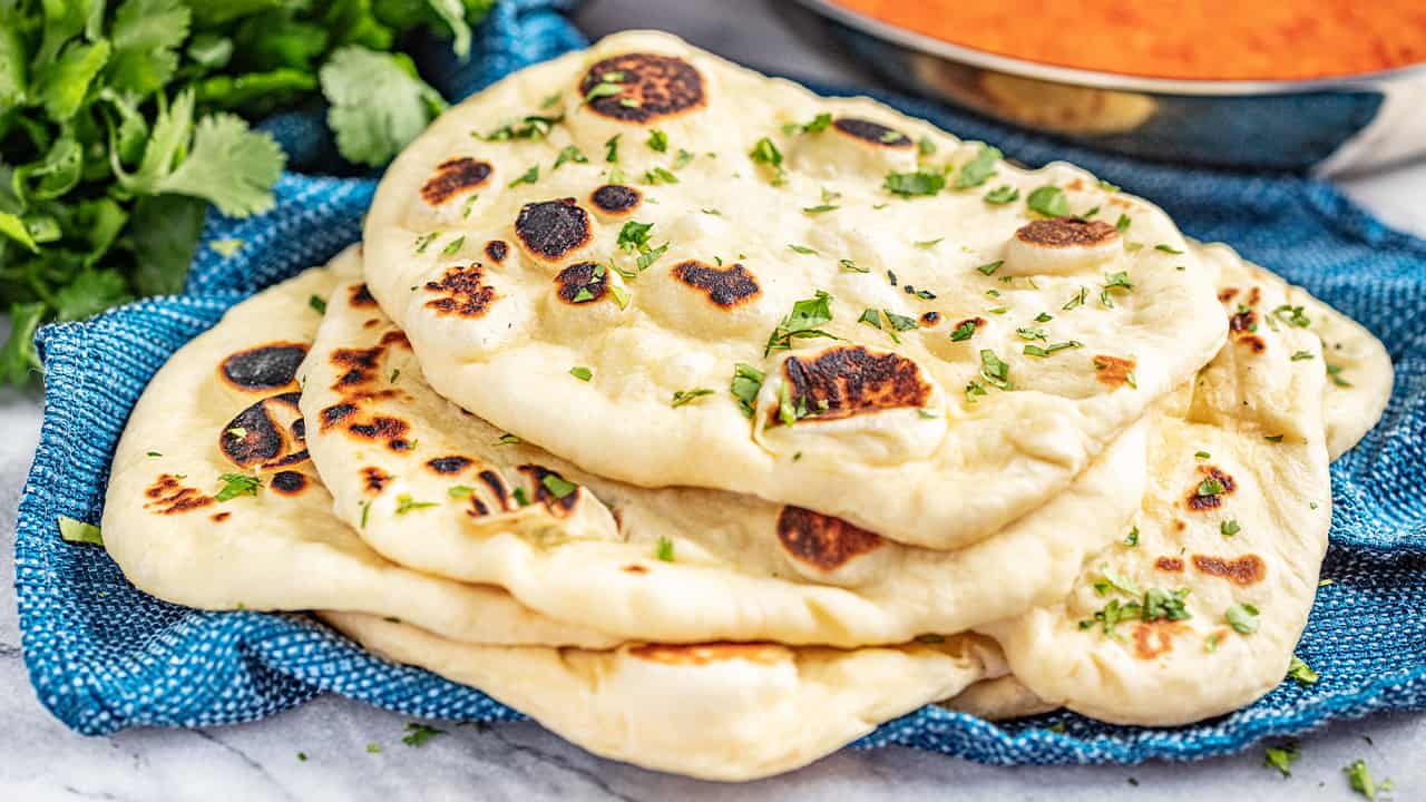 Stack of 5 pieces of naan bread on a blue towel
