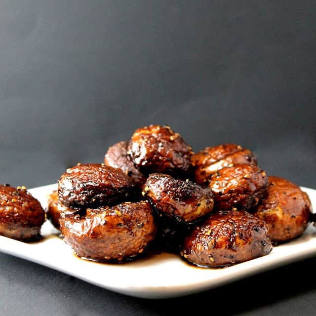 Pile of roasted mushrooms on a white plate