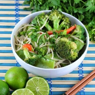 Thai green curry coconut stir fry in white bowl with chopsticks to the side