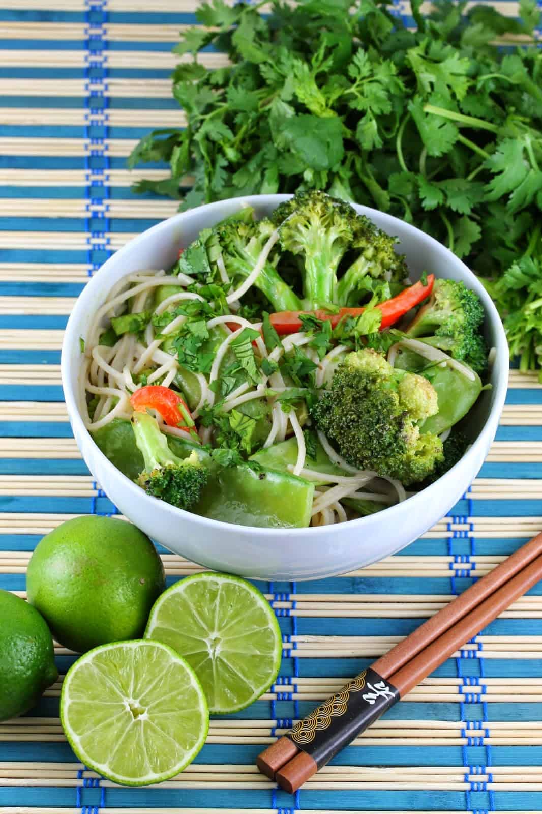 Thai green curry coconut stir fry in white bowl with chopsticks to the side