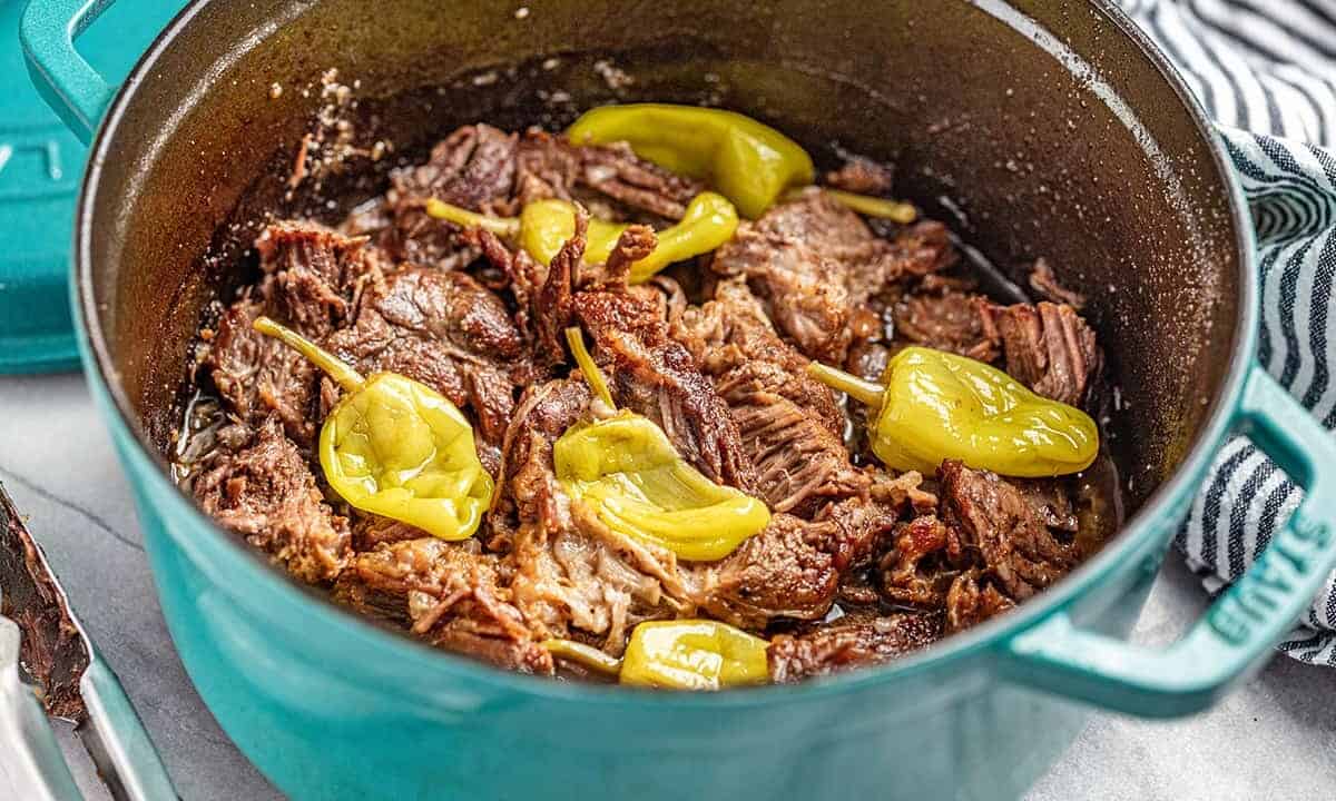 Mississippi pot roast with pepperoncinis in a teal dutch oven