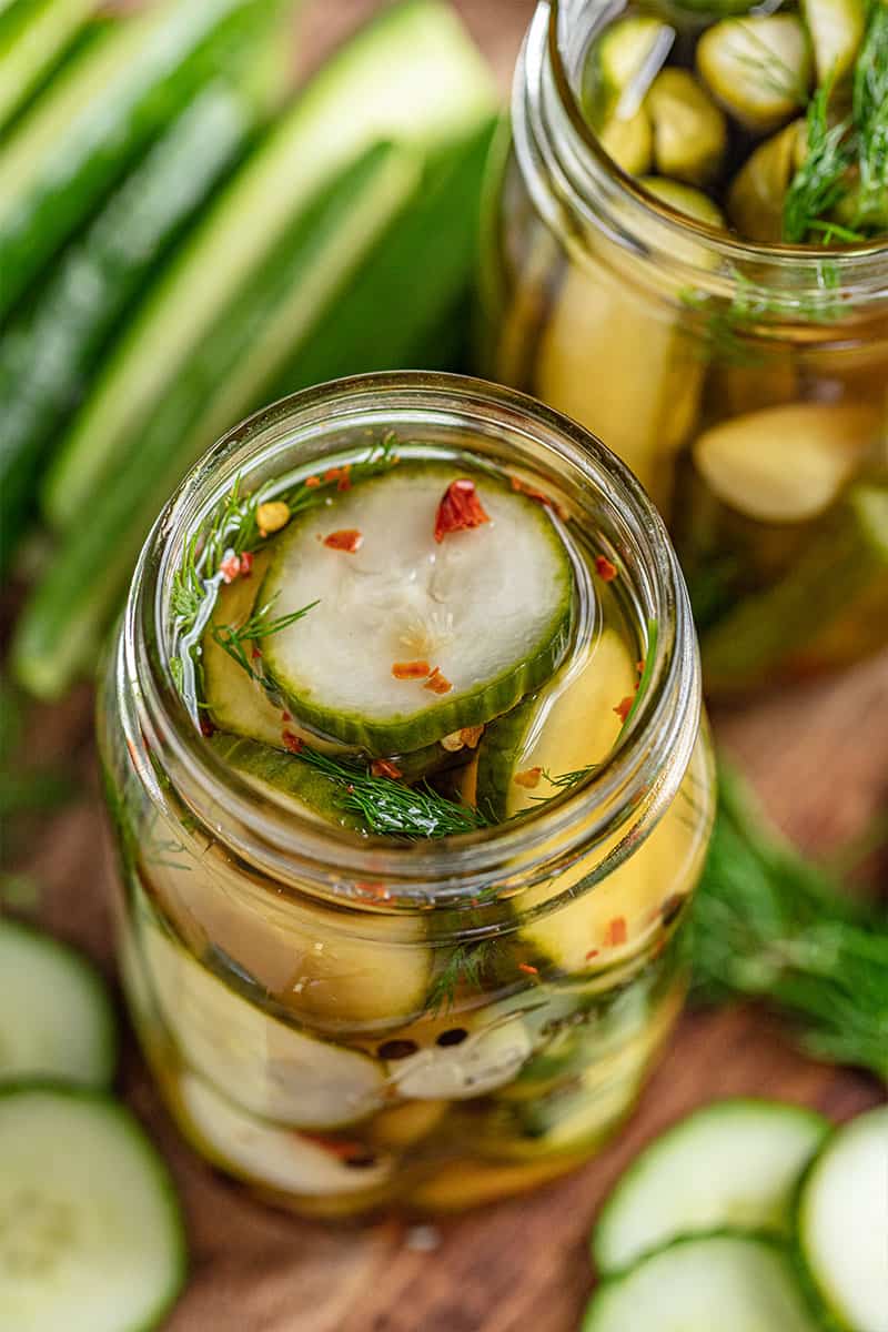 Overhead view into an open jar of sliced pickles