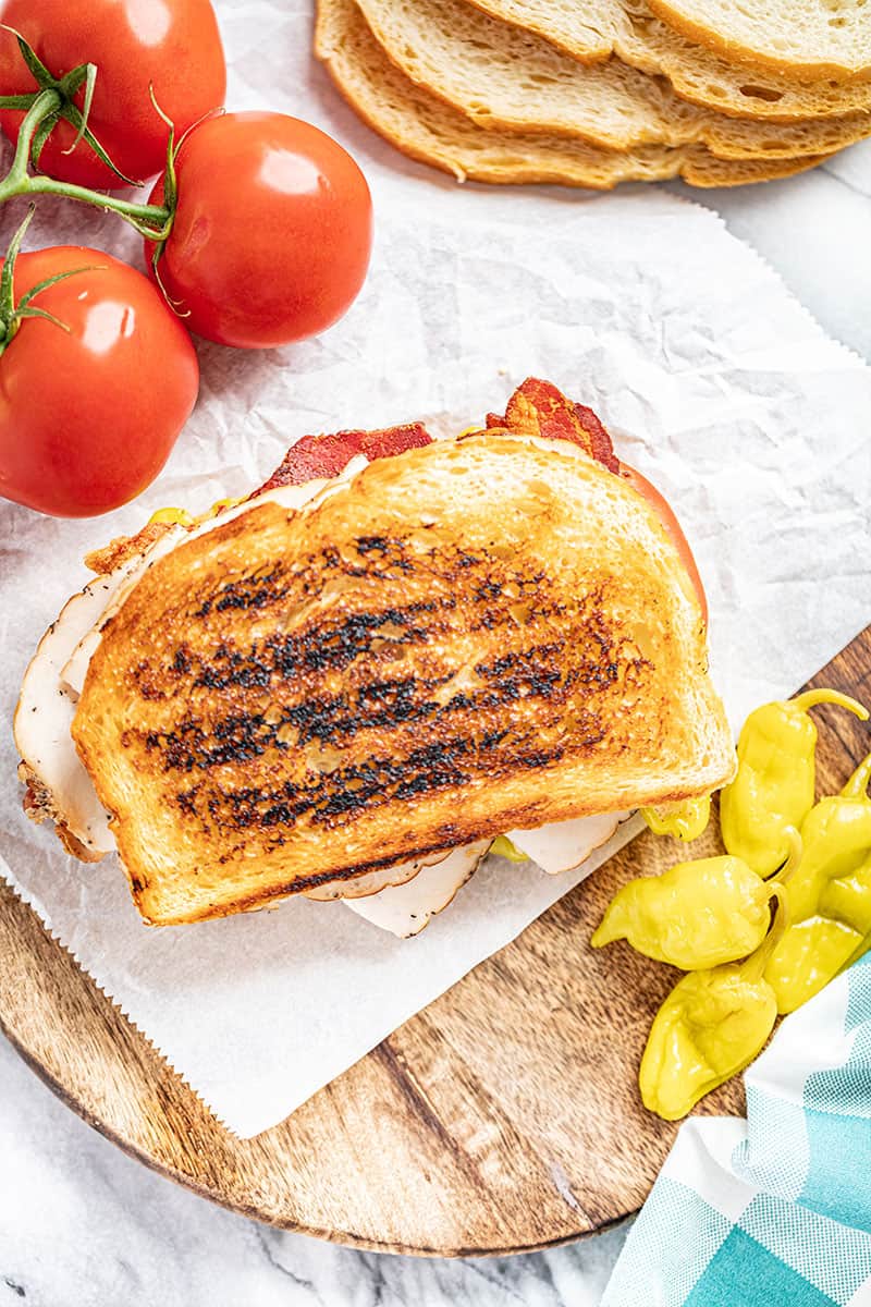 overhead view of an intact Baja turkey club sandwich on wax paper