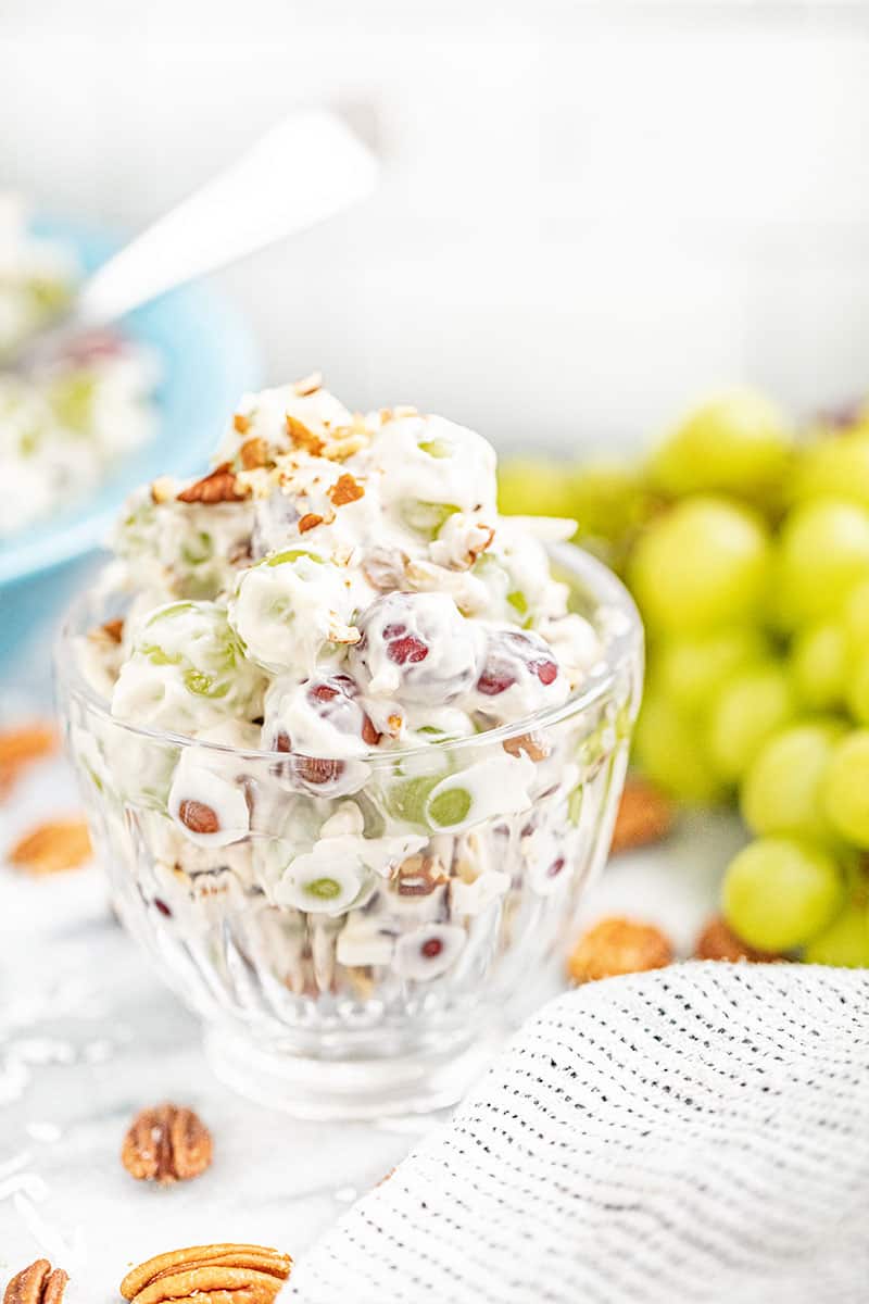Creamy grape salad overfilled in a small glass serving dish