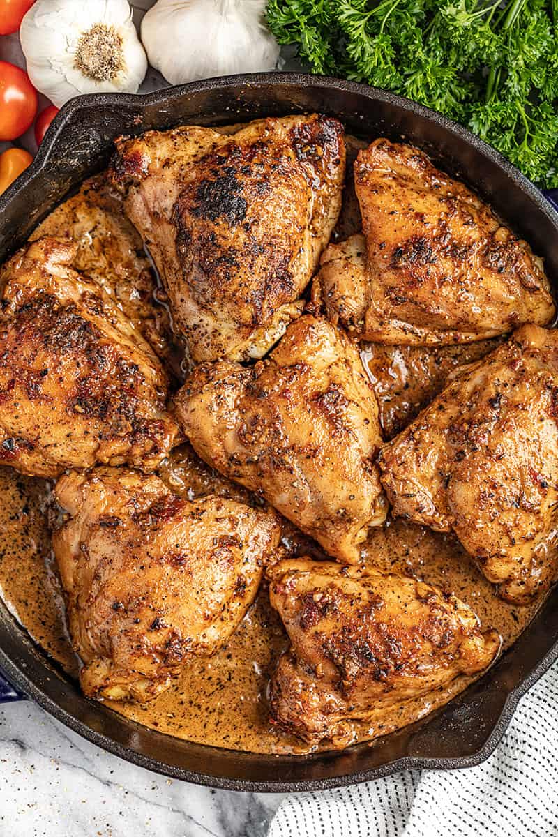 A cast iron skillet with creamy sun dried tomato chicken thighs