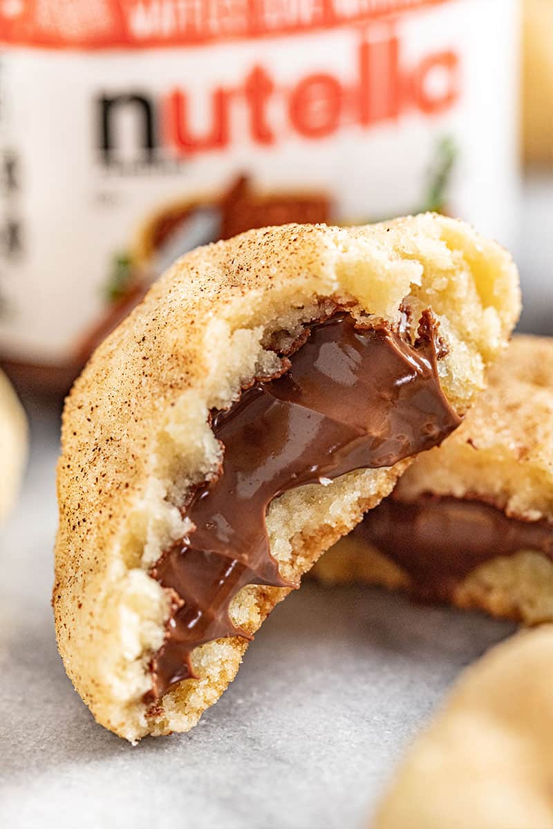 close up view of a churro cookie broken in half to expose the chocolate nutella filling