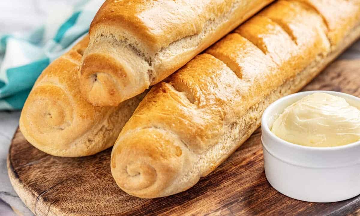 3 loaves of French bread and fresh butter in a ceramic dish