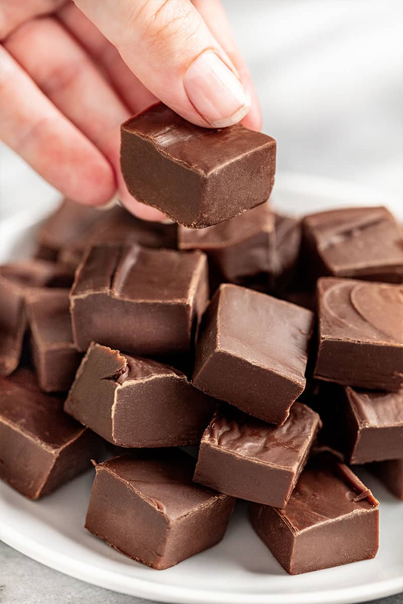 someone holding up one piece of homemade fudge.