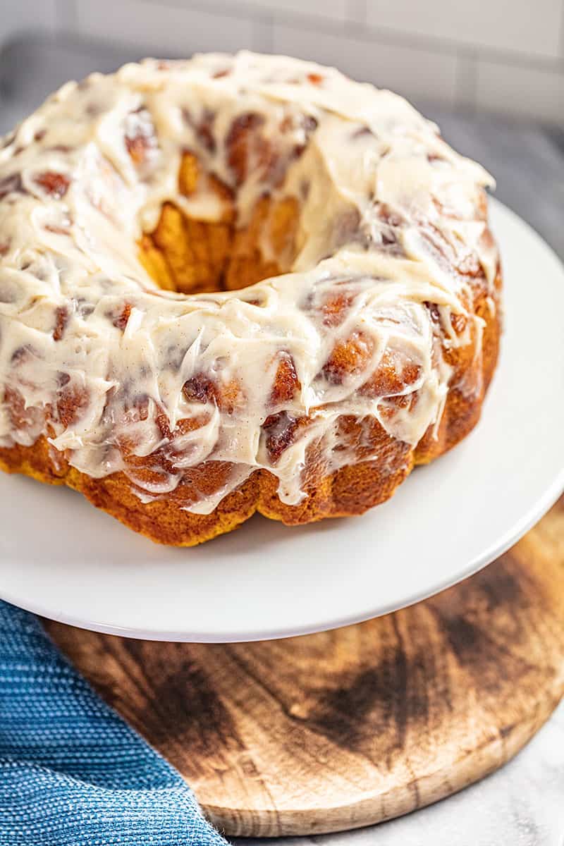 pumpkin pull ahead monkey bread with cream cheese frosting on a cake platter.