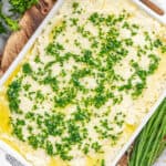 A casserole dish filled with herbed garlic mashed potatoes.