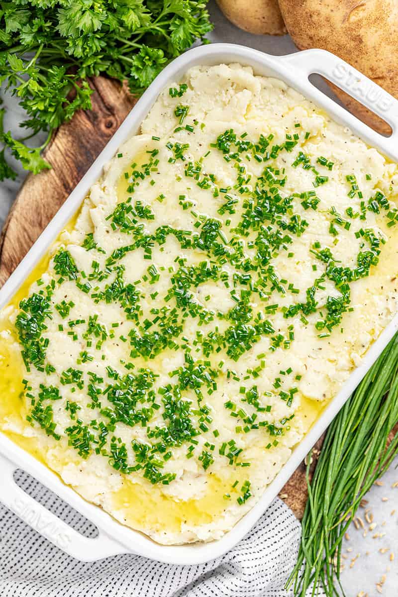 A casserole dish filled with herbed garlic mashed potatoes.