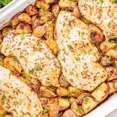Overhead view of a baking dish filled with honey dijon chicken and potatoes.