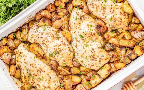Overhead view of a baking dish filled with honey dijon chicken and potatoes.