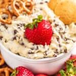 Chocolate chip cookie dough dip with cookies, pretzels, and strawberries.