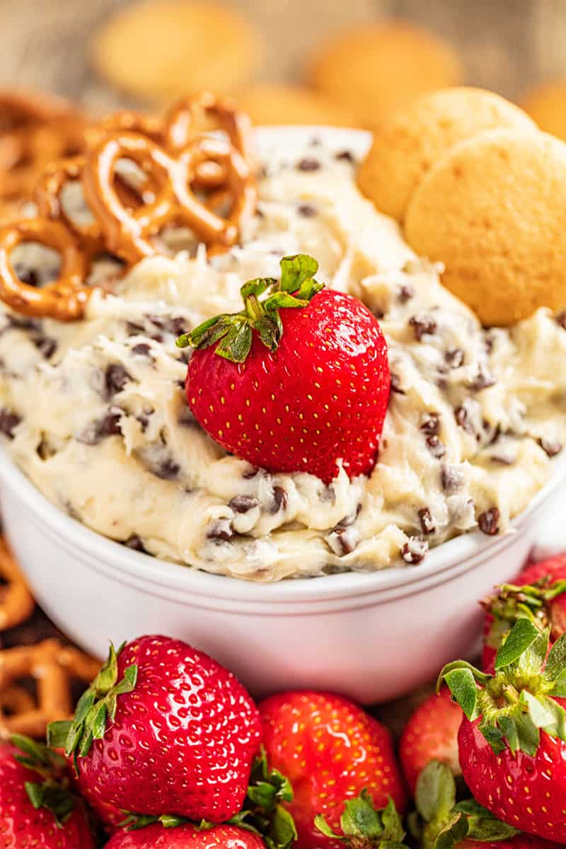 Chocolate chip cookie dough dip with cookies, pretzels, and strawberries.