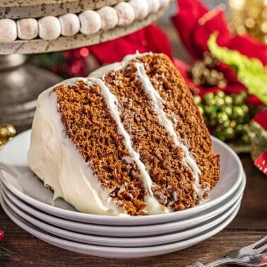 A slice of Christmas gingerbread cake on a stack of plates.