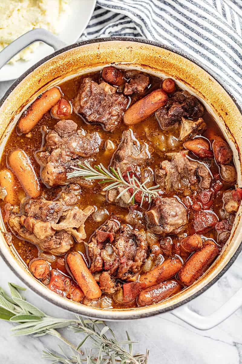 Overhead view of a saucepan filled with braised oxtails.