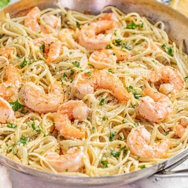 A stainless steel skillet filled with shrimp scampi.