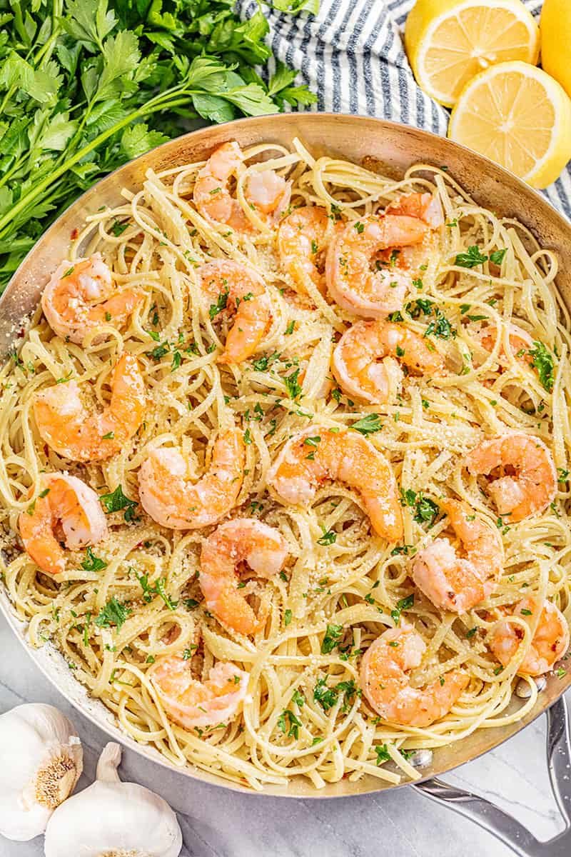 An overhead view of a skillet filled with shrimp scampi.