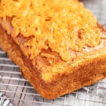 A loaf of cheddar batter bread on a cooling rack.