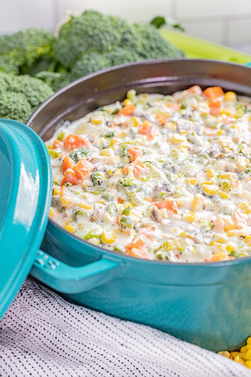 Large blue pot filled with creamy vegetable soup.