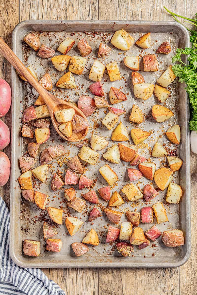 An overhead view of a sheet pan filled with roasted potatoes.