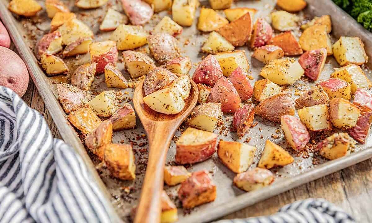 A baking sheet filled with roasted potatoes with the flavors of garlic bread.