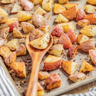 A baking sheet filled with roasted potatoes with the flavors of garlic bread.