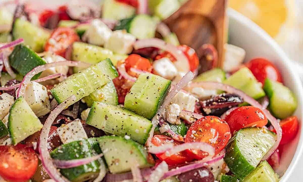 A close up view of a serving bowl filled with greek salad.