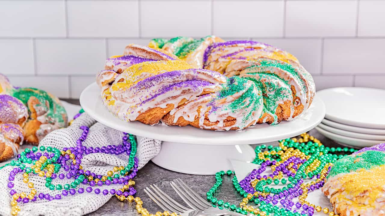 A traditional king cake on a cake stand.
