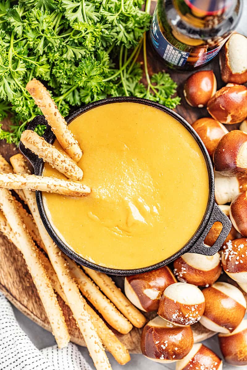 Breadsticks in a pot of beer cheese dip.