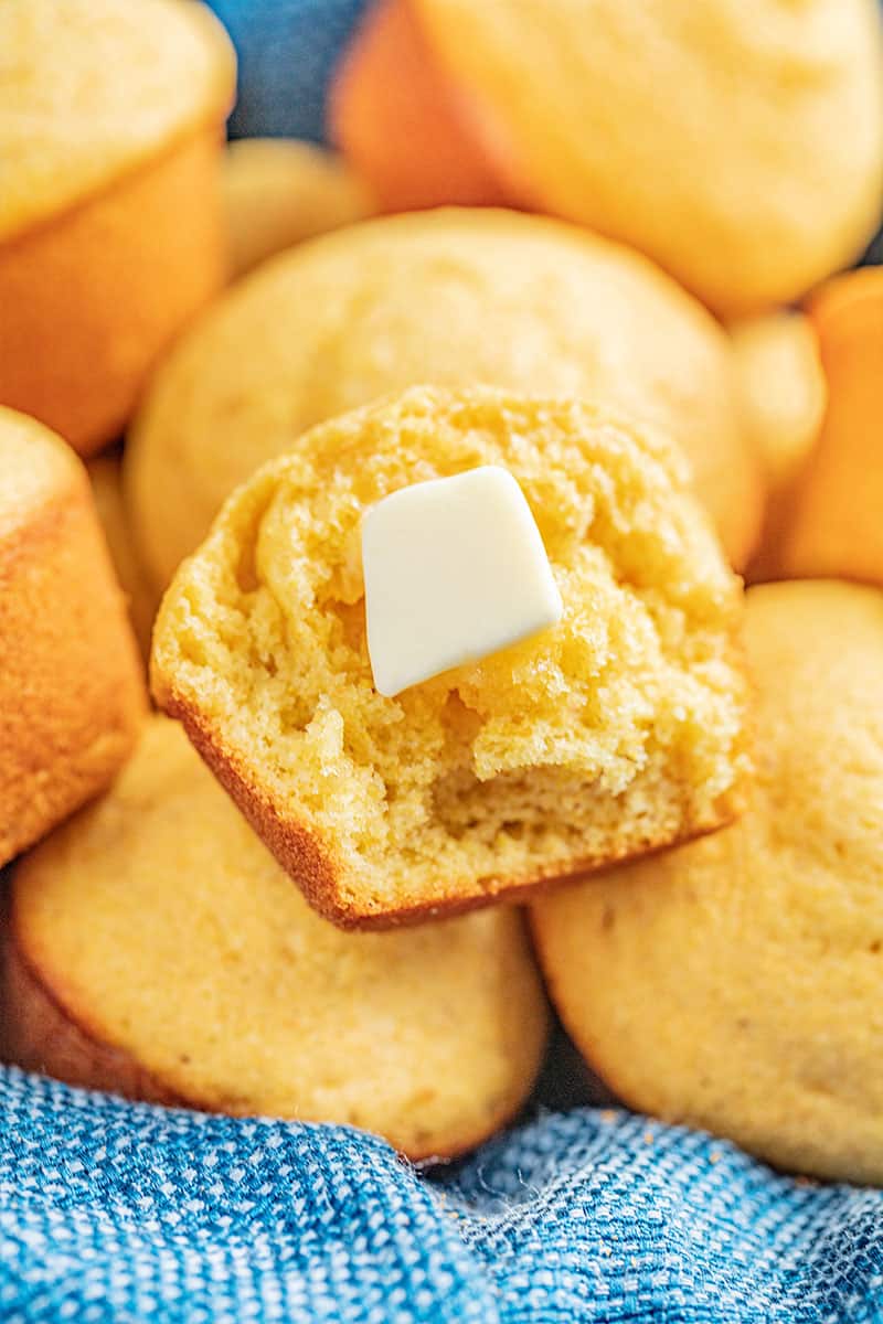 A half of a cornbread muffin with a pat of butter.