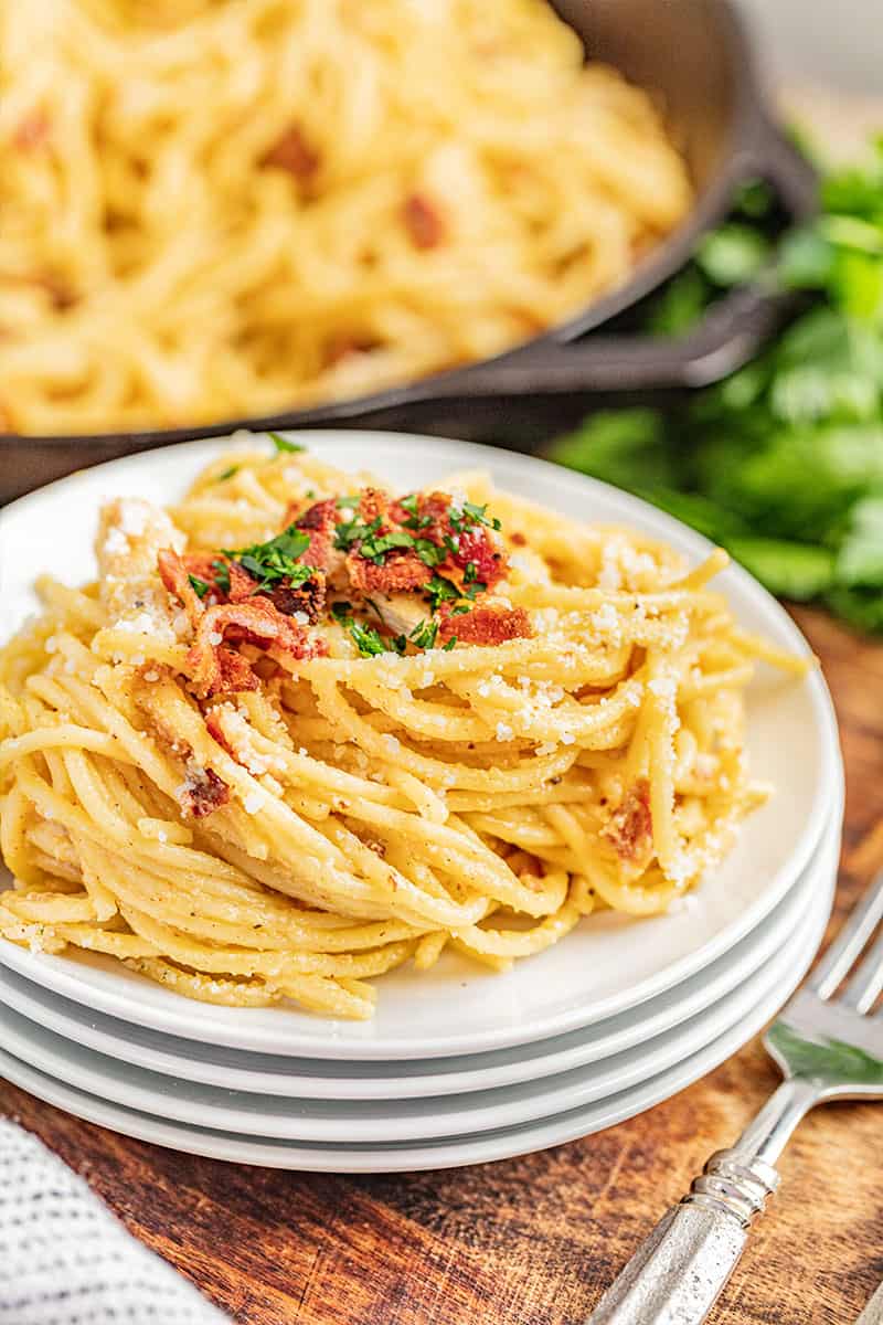 Chicken carbonara on a stack of plates.