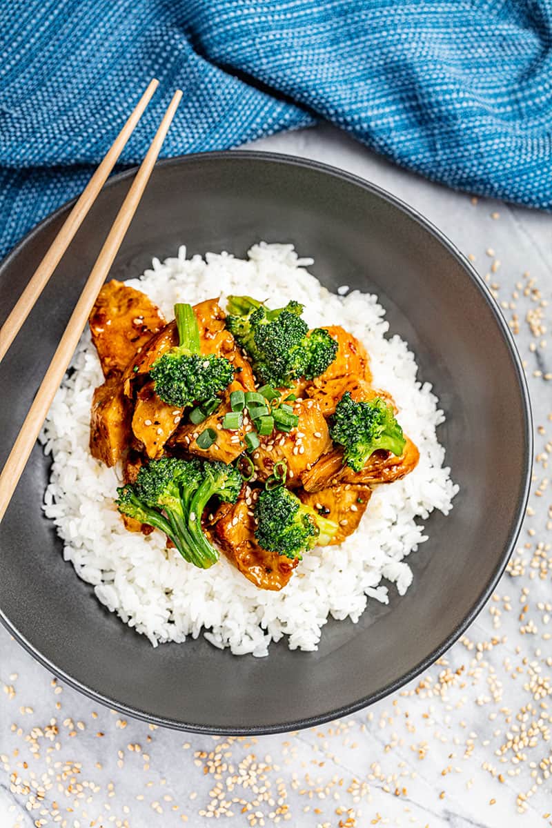 Overhead view of chicken teriyaki with broccoli over rice in a bowl.