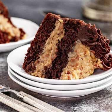 A slice of german chocolate cake sitting on a stack of plates