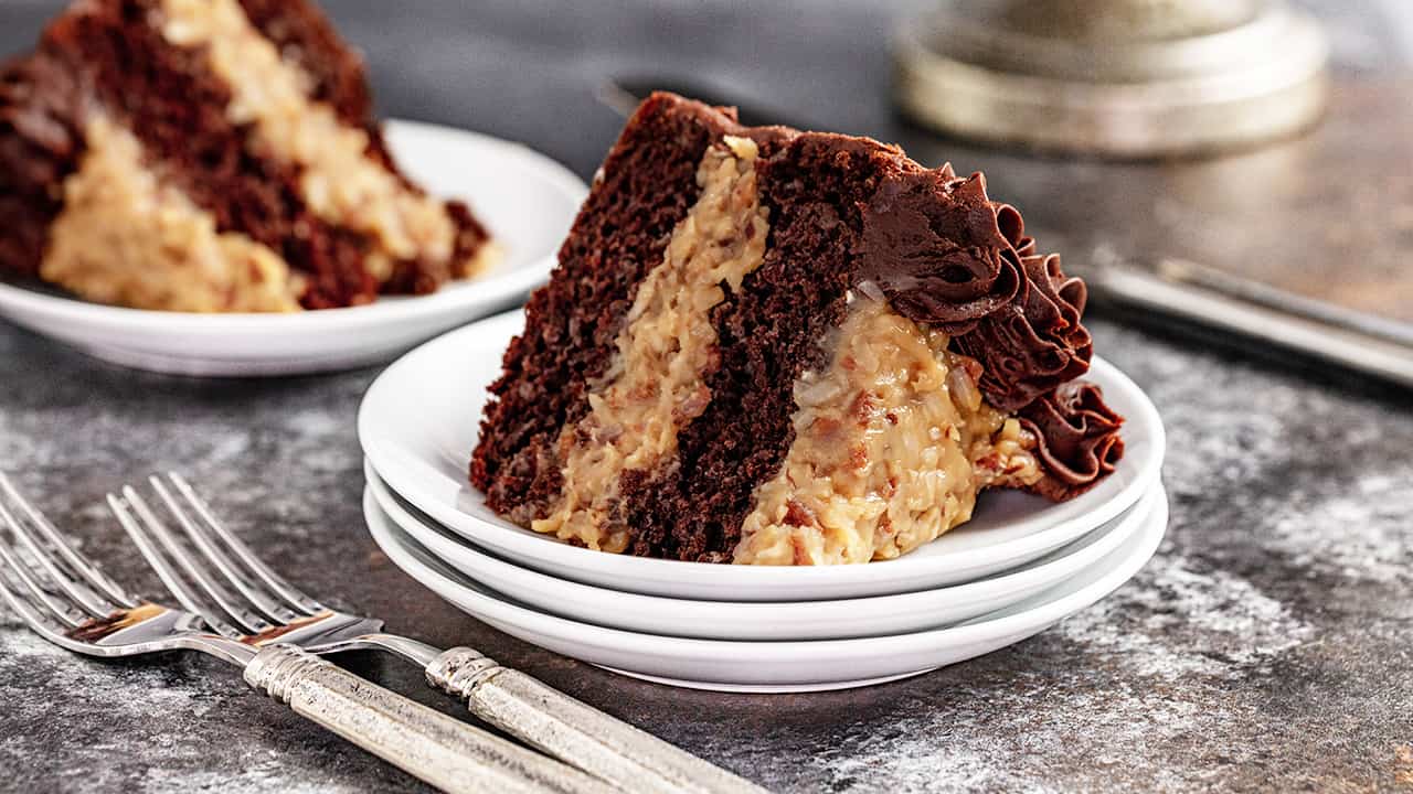 A slice of german chocolate cake sitting on a stack of plates
