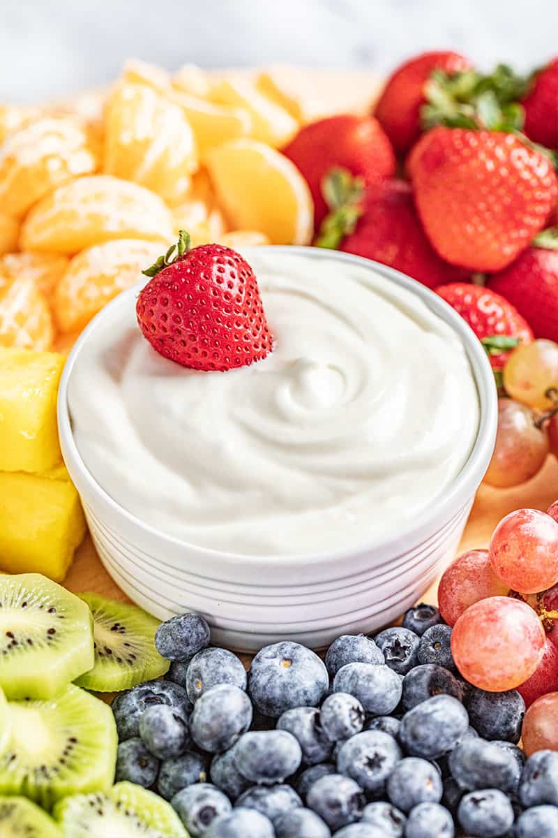 Nutella and greek yogurt fruit dip surrounded by fruit.