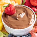 Nutella fruit dip in a ramekin with a strawberry on top.
