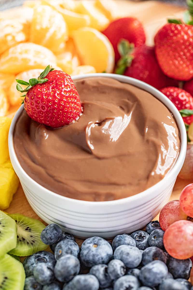 Nutella fruit dip in a ramekin with a strawberry on top.