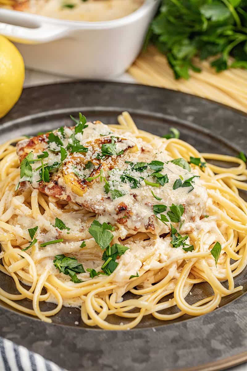 Chicken francese with spaghetti on a dinner plate.