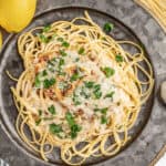 A dinner plate filled with chicken francese and spaghetti noodles.