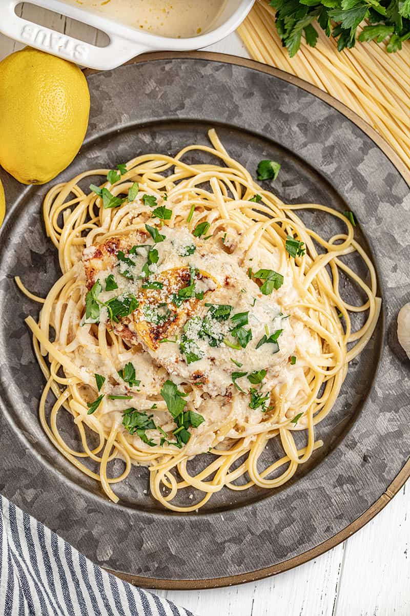 A dinner plate filled with chicken francese and spaghetti noodles.