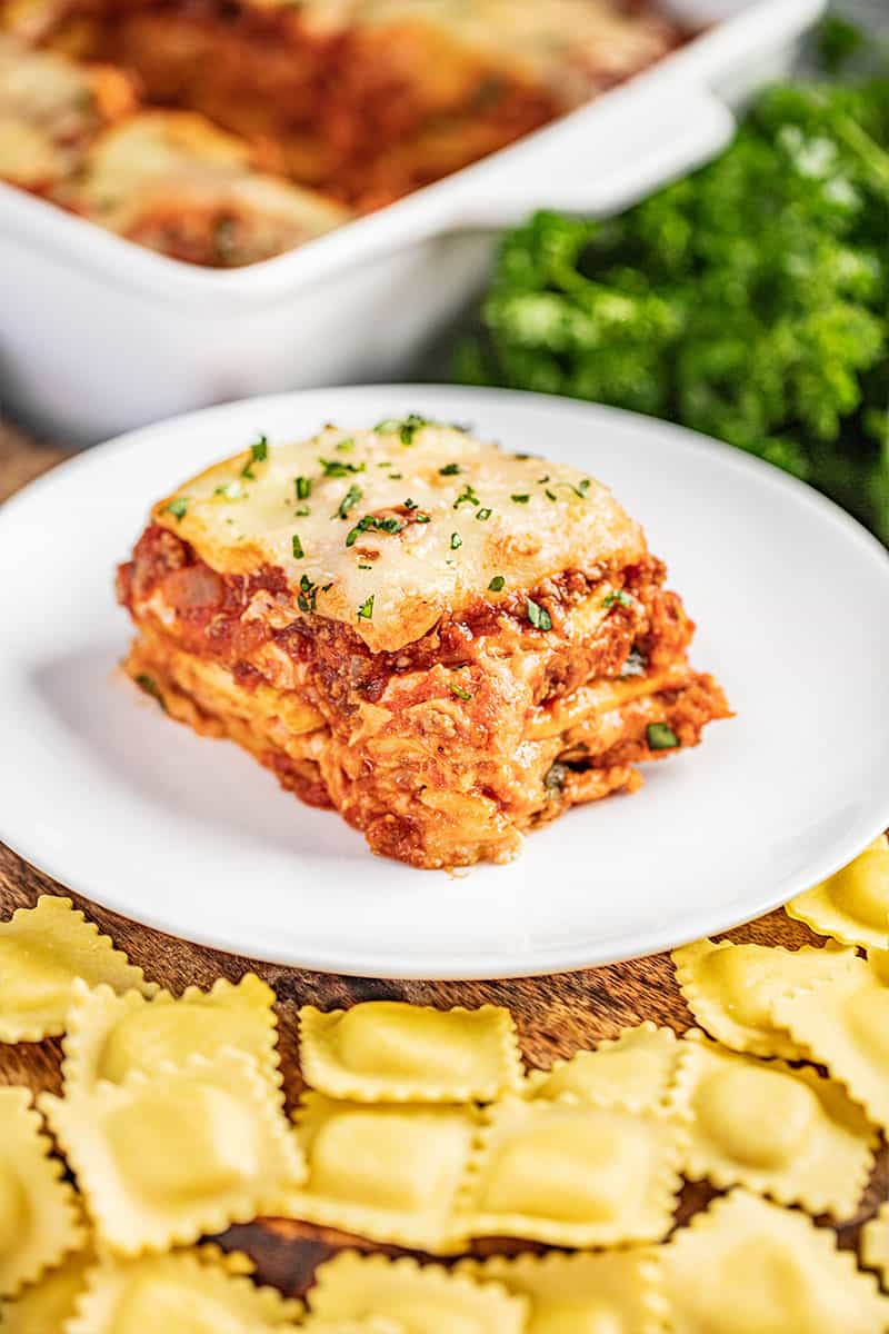 A slice of ravioli lasagna on a white dinner plate.